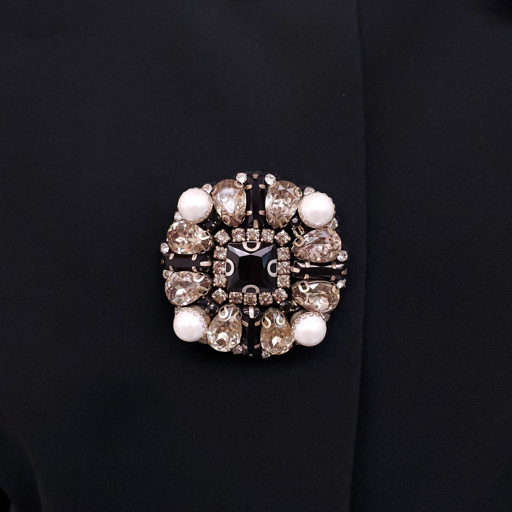 ANDREW GN BLACK SKIRT SUIT WITH FLORAL EYELET COLLAR AND CRYSTAL EMBLEM DETAILS - SIZE 46